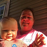Hudson Kinley is registered to the contest to win money with this photo: baby, child, woman, smiling, striped_clothing, captain_america_logo, hand, porch, window, siding, sunlight, outdoor, person, face, happy, casual, daylight, closeup, family, holding