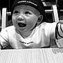 baby, child, smiling, hat, cap, under_armour, high_chair, table, wood, indoor, black_and_white, happy, cute, clothing, face, person, portrait, expression, joy, toddler