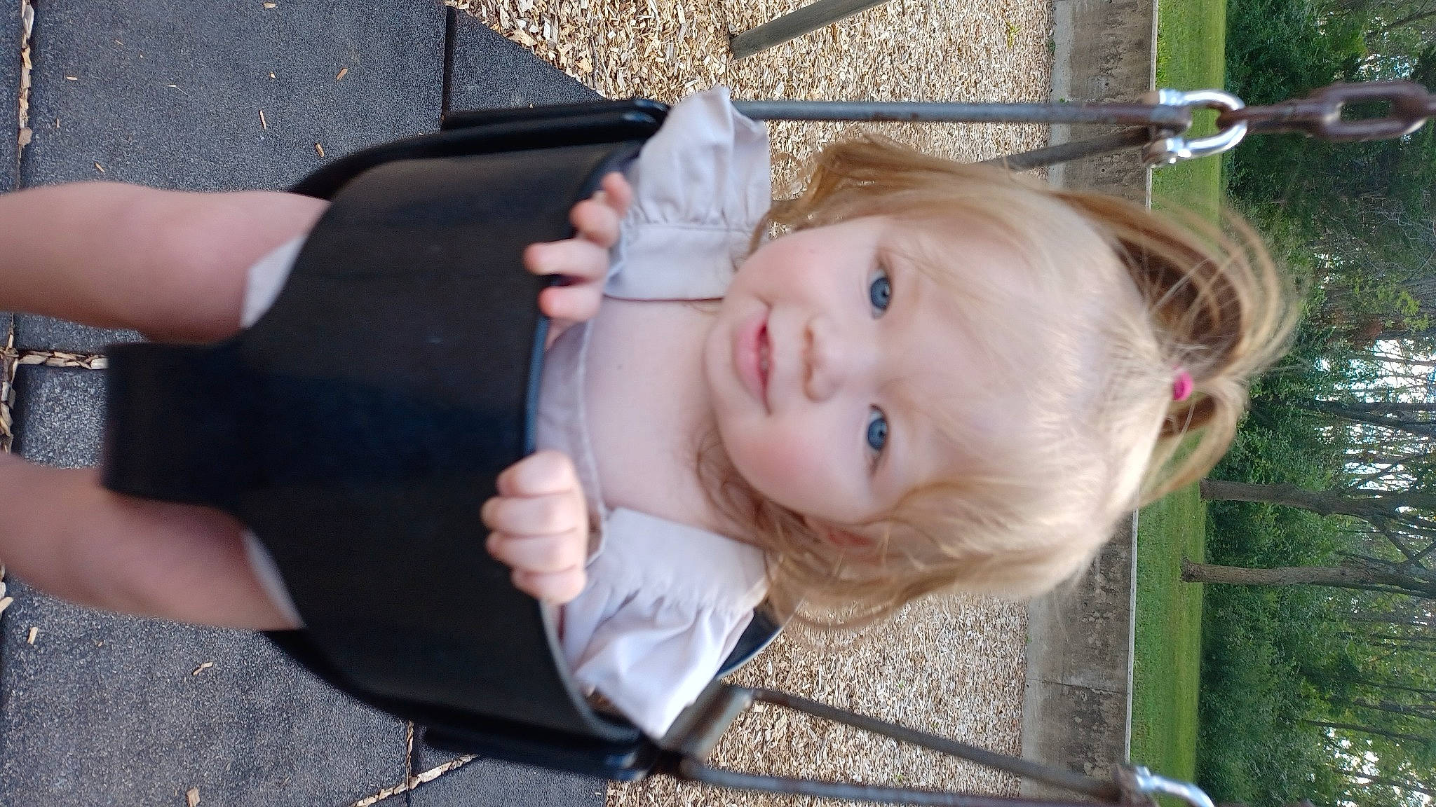 Evie is registered to the contest to win money with this photo: baby, baby_toddler_clothing, cheek, child, eye, face, fun, gesture, grass, happy, head, lip, nose, person, plant, sitting, skin, smile, toddler, tree