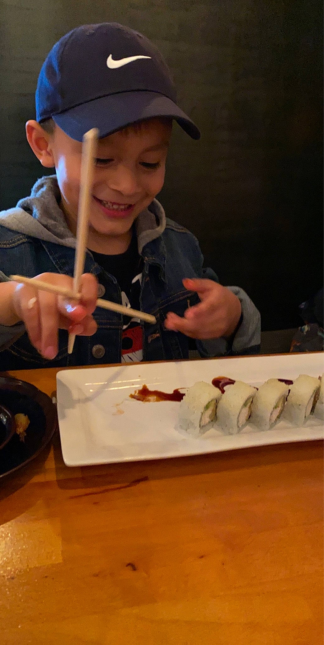 Héctor is registered to the contest to win money with this photo: baseball_cap, cap, chair, chopsticks, comfort_food, cooking, cuisine, dish, finger, food, food_craving, hand, headwear, joy, kitchen_utensil, person, plate, recipe, smile, t_shirt