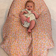 Hazel participe au concours pour gagner de l'argent avec cette photo : baby, child, clothing, comfort, cushion, cute, expression, floor, floral_pattern, foot, head, indoors, infant, looking, one_person, person, relaxing, sitting, skin, small