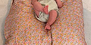 Hazel participe au concours pour gagner de l'argent avec cette photo : baby, child, clothing, comfort, cushion, cute, expression, floor, floral_pattern, foot, head, indoors, infant, looking, one_person, person, relaxing, sitting, skin, small