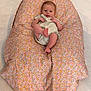 baby, child, clothing, comfort, cushion, cute, expression, floor, floral_pattern, foot, head, indoors, infant, looking, one_person, person, relaxing, sitting, skin, small