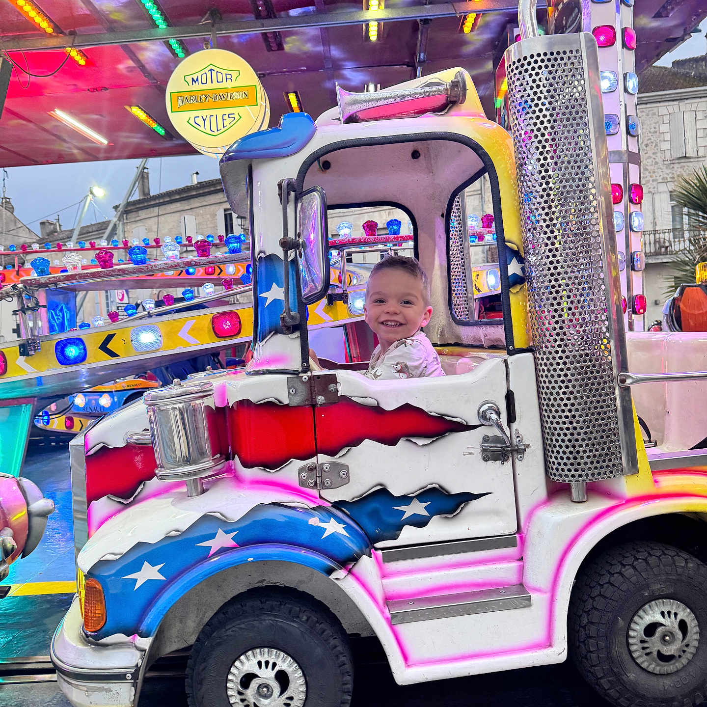 Hugo a rejoint le concours — aidez-le/la à gagner de superbes lots ! baby, bumper, car, clothing, face, head, indoors, machine, outdoors, person, photography, playarea, portrait, shorts, spoke, tire, transportation, urban, vehicle, wheel