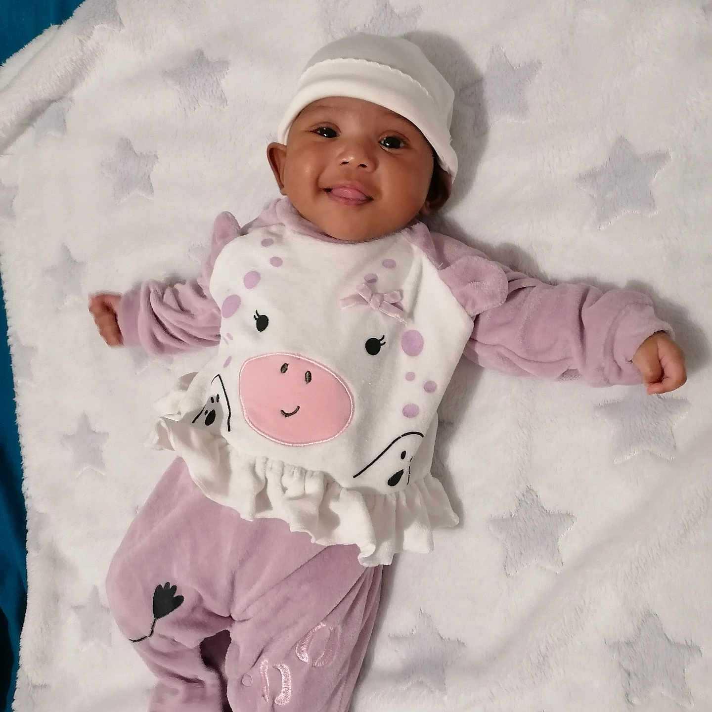 Kailea a rejoint le concours — aidez-le/la à gagner de superbes lots ! baby, blanket, child, cozy, cute, face, happy, hat, indoors, infant, lying_down, one_person, playful, portrait, purple_clothing, smiling, soft_texture, star_pattern, tongue_out, white_clothing