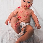Samuel is registered to the contest to win money with this photo: baby, infant, diaper, lipstick_marks, face, foot, hand, skin, blue_eyes, lying_down, white_sheet, cute, chubby, playful, child, expression, human, portrait, body, adorable