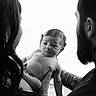 baby, infant, man, woman, tattoos, black_and_white, portrait, family, holding, togetherness, love, parenthood, hands, calm, indoor, expression, closeup, skin, people, gentle