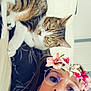 woman, cat, glasses, flower_crown, selfie, tabby_cat, indoor, couch, pet, face, casual, relaxed, curious, fur, whiskers, portrait, home, comfort, filter, glasses_reflection