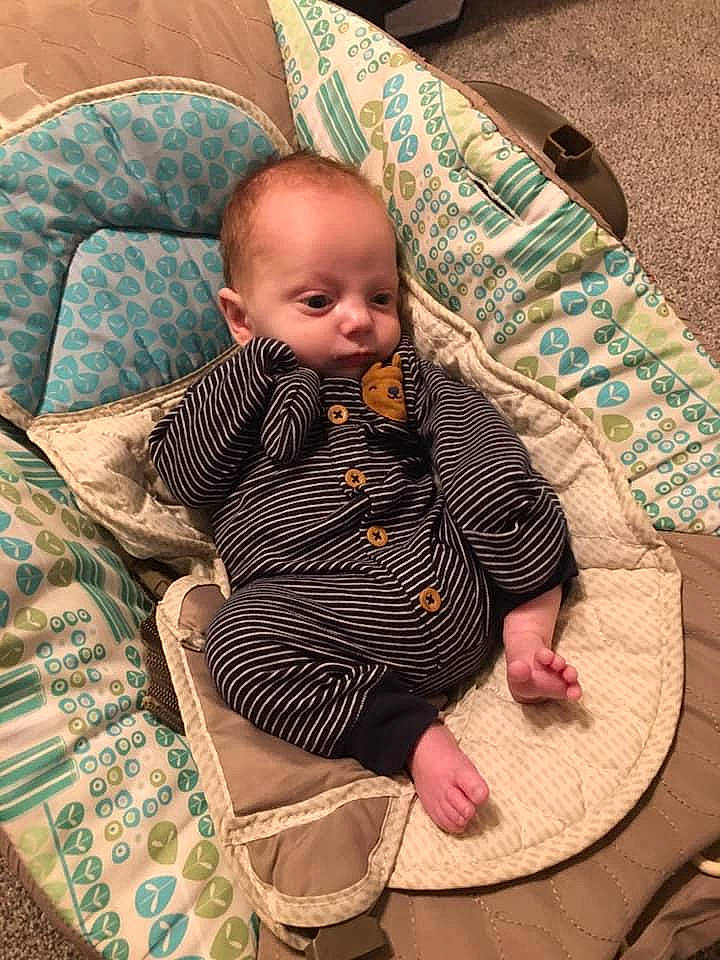Parker is registered to the contest to win money with this photo: baby, baby_products, baby_toddler_clothing, chair, cheek, child, comfort, face, finger, flooring, head, human_body, iris, lap, linens, person, skin, sleeve, textile, toddler
