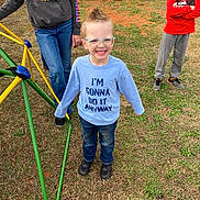 Parker joined the competition — help win amazing prizes! child, boy, glasses, mohawk, smile, shirt, jeans, shoes, playground, grass, backyard, fence, person, casual_clothing, outdoor, happy, friends, kids, play, daytime
