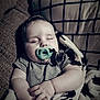 baby, blanket, child, comfort, couch, cozy, cute, face, hands, indoors, infant, pacifier, peaceful, pillow, portrait, relaxing, resting, sleeping, soft_lighting, striped_clothing