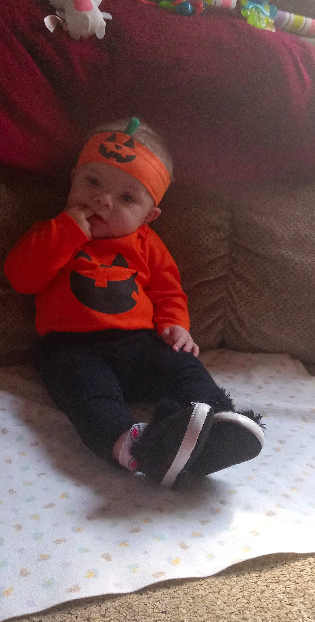 Lilly is registered to the contest to win money with this photo: baby, baby_toddler_clothing, beanie, cap, carmine, child, costume, costume_hat, fictional_character, flooring, fun, hat, headwear, human_body, person, pumpkin, sitting, sleeve, toddler, trick_or_treat
