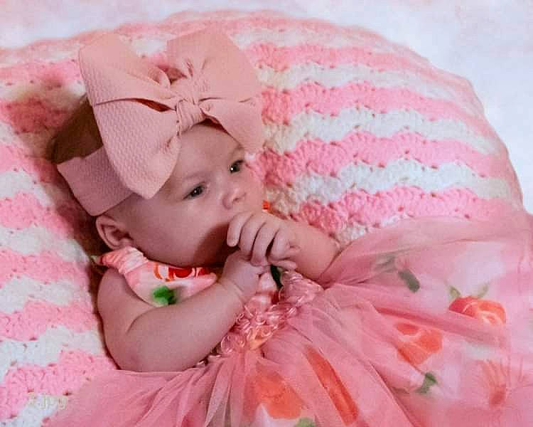 Lilly joined the competition — help win amazing prizes! baby, baby_sleeping, baby_toddler_clothing, child, comfort, dress, finger, headgear, headpiece, linens, lip, pattern, peach, person, petal, pink, skin, sleeve, sweetness, textile