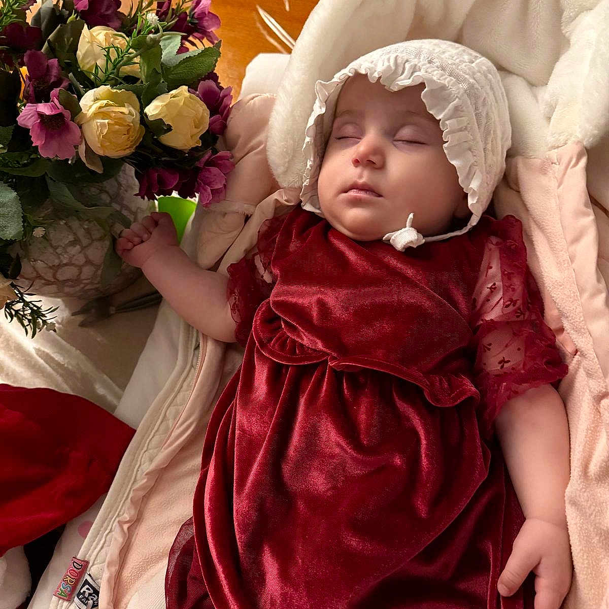 Francline participe au concours pour gagner de l'argent avec cette photo : baby, blanket, bonnet, clothing, cushion, dress, face, flower, flowerarrangement, flowerbouquet, hat, head, homedecor, person, petal, photography, plant, portrait, rose, sleeping