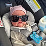 baby, car_seat, sunglasses, pink_hat, pacifier, infant, child, seatbelt, clothing, cute, baby_girl, hat, gray_harness, indoor, portrait, baby_accessory, baby_clothes, car_interior, baby_face, relaxing