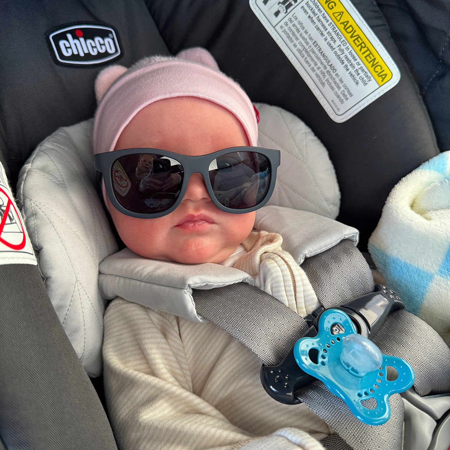 Lydia is registered to the contest to win money with this photo: baby, baby_accessory, baby_clothes, baby_face, baby_girl, car_interior, car_seat, child, clothing, cute, gray_harness, hat, indoor, infant, pacifier, pink_hat, portrait, relaxing, seatbelt, sunglasses