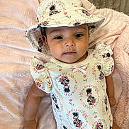 Juliette joined the competition — help win amazing prizes! baby, infant, child, hat, bucket_hat, floral_pattern, minnie_mouse, onesie, pink_blanket, soft_texture, cute, portrait, lying_down, clothing, apparel, smiling, face, skin, person, indoors