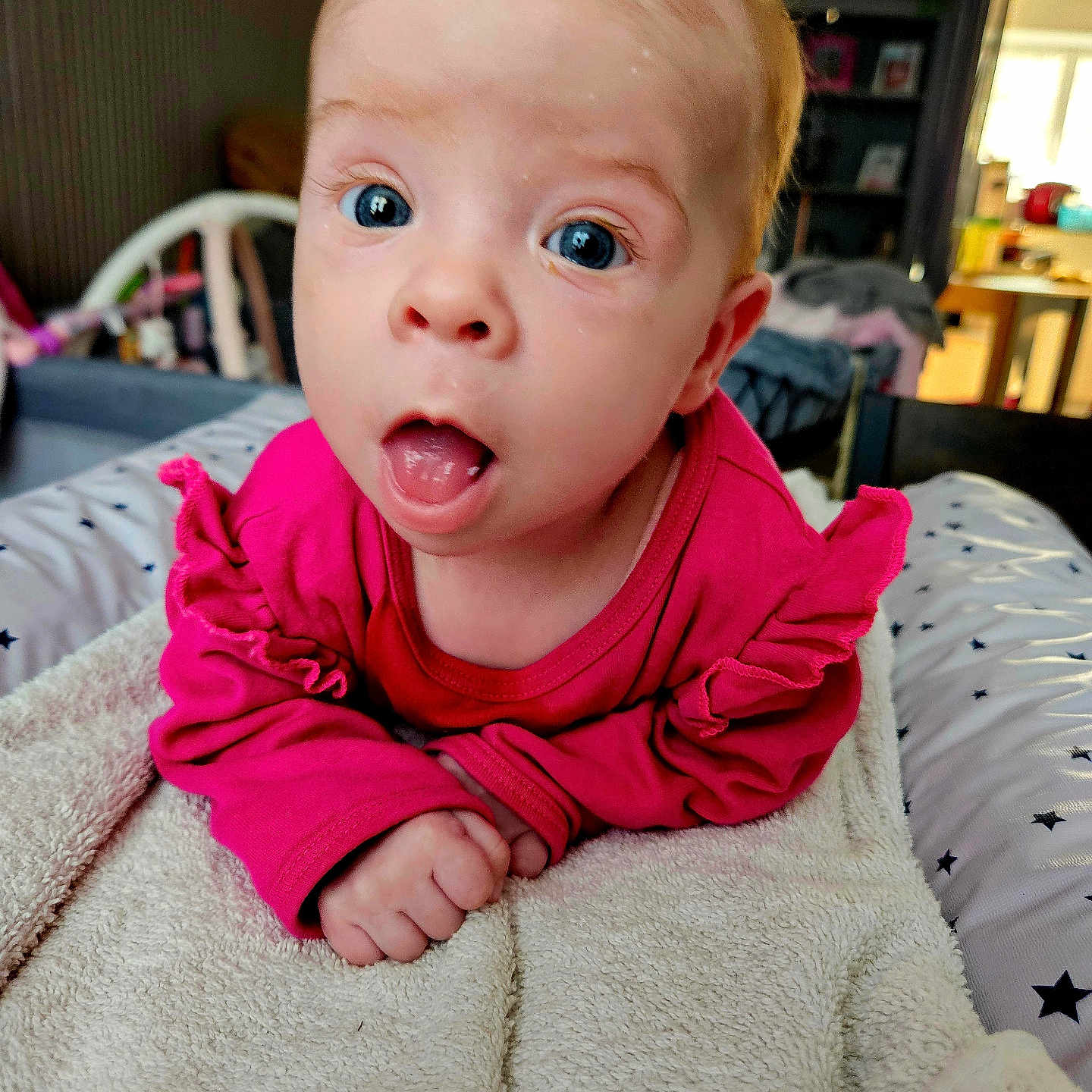 Ambre a rejoint le concours — aidez-le/la à gagner de superbes lots ! baby, blanket, child, close_up, couch, curious_expression, face, furniture, hands, head, home, indoor, infant, person, pink_clothing, portrait, room, soft_lighting, towel, wide_eyes