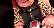 Remedy is registered to the contest to win money with this photo: baby, car_seat, cheeky, child, close_up, clothing, cute, expression, hands, happy, indoor, infant, leopard_print, person, portrait, red_lighting, safety_harness, seatbelt, smiling, young_child