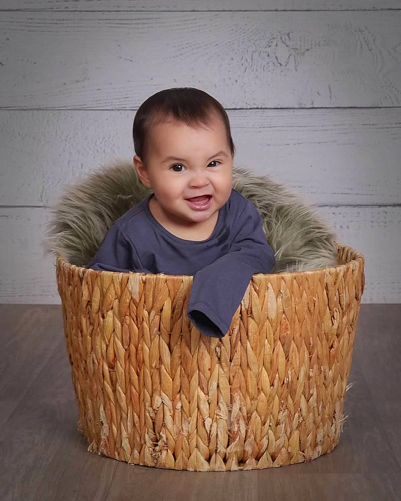 Amara is registered to the contest to win money with this photo: baby, baby_toddler_clothing, basket, box, comfort, flash_photography, flooring, fun, grass, happy, hardwood, joy, laugh, packing_materials, person, rectangle, sitting, smile, storage_basket, toddler