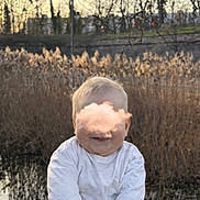 Kémys participe au concours pour gagner de l'argent avec cette photo : baby, infant, child, sitting, rock, pond, water, reeds, tall_grass, trees, bare_branches, sunset, sky, cloud_sticker, white_shirt, socks, smile, outdoors, portrait, nature