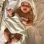 baby, towel, bed, white, blanket, child, cute, smiling, tongue_out, infant, soft, sleepwear, happy, playful, skin, lying_down, indoors, hooded_towel, person, newborn