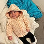 baby, hoodie, floral_pattern, black_leggings, white_socks, blanket, bedding, bed, infant, child, cute, smiling, indoors, relaxed, lying_down, face, person, soft, warm_clothing, casual