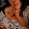 Kailee is registered to the contest to win money with this photo: baby, infant, adult, mother, portrait, selfie, smiling, tongue_out, cuddling, close_up, indoors, bed, blanket, patterned_clothing, white_shirt, hand, chewing, happy, family, casual_photo