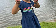 Sevyn is registered to the contest to win money with this photo: blue_dress, casual_clothing, child, curly_hair, daytime, girl, grass, greenery, lake, minnie_mouse, nature, outdoor, peace_sign, playful, pucker_lips, smiling, standing, summer, water, young