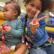 Sevyn joined the competition — help win amazing prizes! baby, casual_clothing, child, curly_hair, cute, denim_jacket, diaper, family, happy, indoor, infant, keychain, peace_sign, person, playful, portrait, sitting, smiling, toddler, toys
