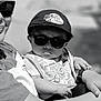 baby, child, sunglasses, cap, person, arm, hand, clothing, outdoor, portrait, black_and_white, cool, fashion, cute, infant, hat, holding, sunlight, casual, baby_bib