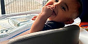 Kenai joined the competition — help win amazing prizes! baby, child, high_chair, indoor, smiling, happy, face, hand, hair, spiky_hair, fingers, window, door, mesh_screen, car, bicycle, plastic, seat, playful, person