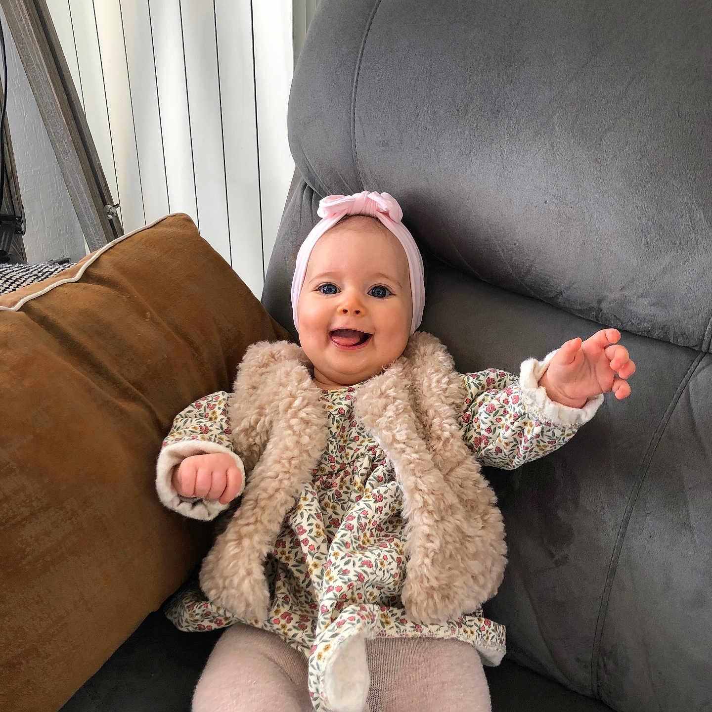 Pia participe au concours pour gagner de l'argent avec cette photo : baby, child, clothing, couch, cozy, cute, floral, furniture, happy, headband, indoor, pattern, person, pink, portrait, seated, smiling, toddler, vest, warm