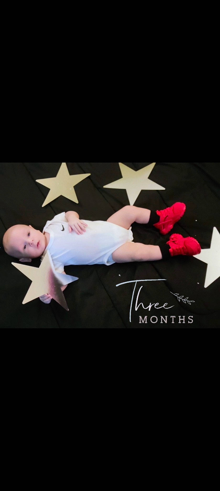 Nixon is registered to the contest to win money with this photo: carmine, darkness, entertainment, event, flash_photography, flooring, font, gesture, graphics, happy, human_leg, logo, magenta, performing_arts, person, petal, room, sitting, sportswear, t_shirt