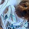 Suki joined the competition — help win amazing prizes! dog, pet, fur, close_up, white_shirt, sports_jersey, adidas, fifa_patch, hand, curly_hair, indoor, texture, fabric, casual, brown_dog, portrait, cute, companion, resting, cozy