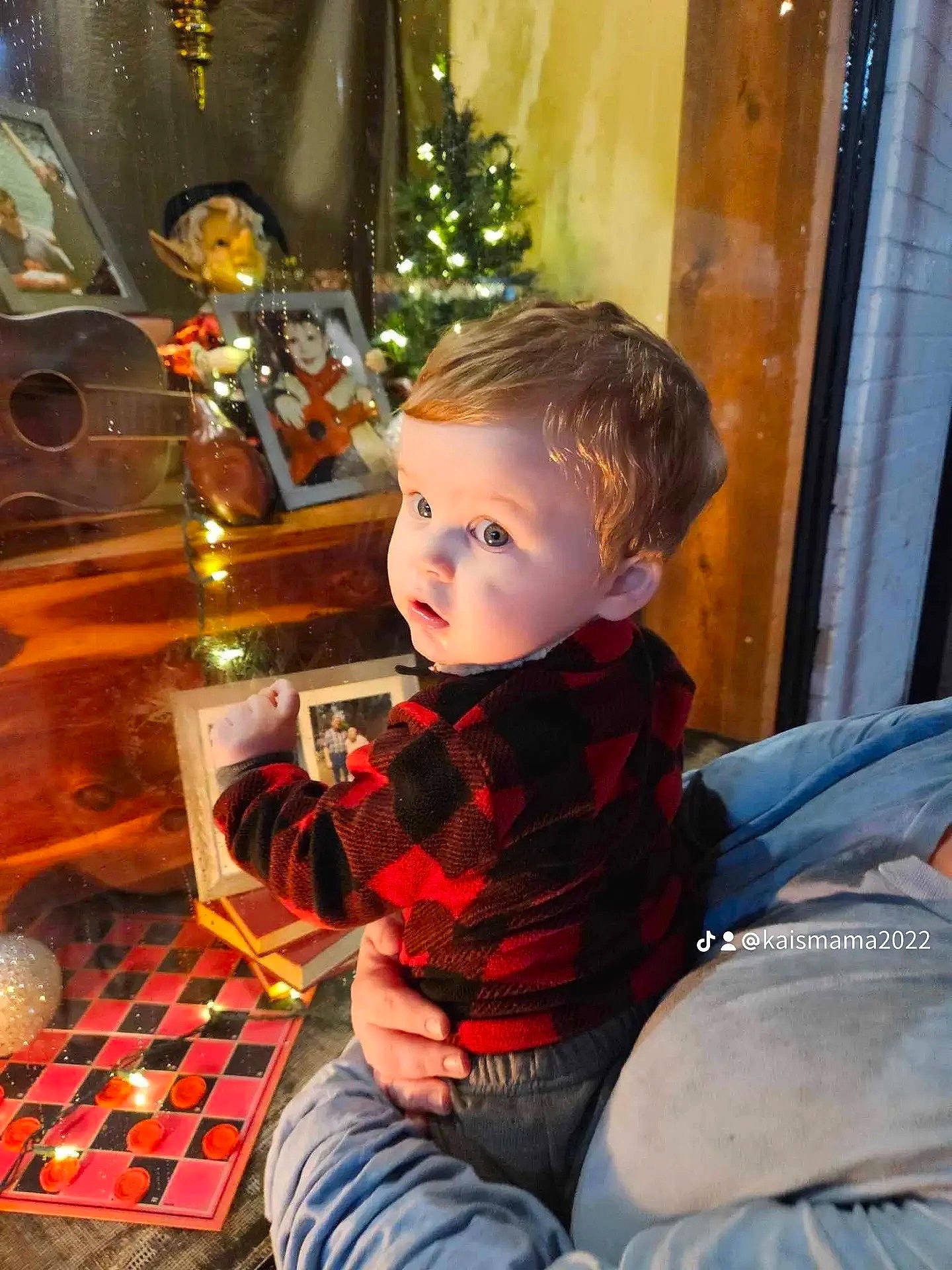 Malakai is registered to the contest to win money with this photo: chair, child, christmas, christmas_eve, denim, event, flooring, fun, happy, holiday, lap, leisure, ornament, pattern, person, room, sitting, toddler, tree, vacation