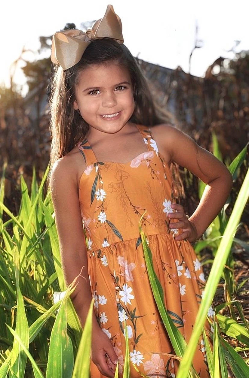 Bailee is registered to the contest to win money with this photo: abdomen, black_hair, child, dress, eye, facial_expression, flash_photography, grass, grassland, hair, happy, iris, joy, long_hair, meadow, people_in_nature, person, plant, skin, smile