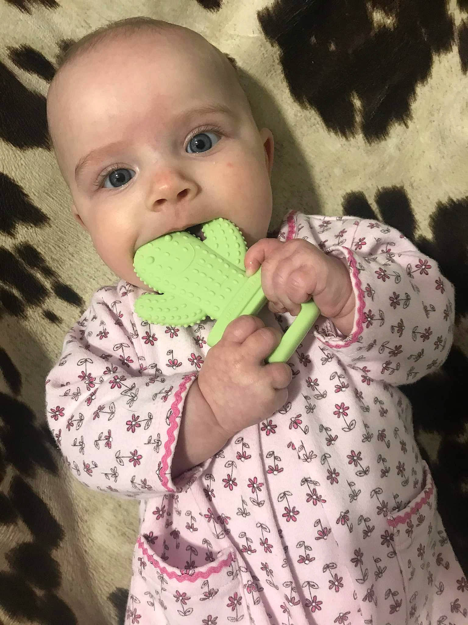 Emmerson is registered to the contest to win money with this photo: baby, baby_toddler_clothing, cheek, child, comfort, finger, gesture, happy, human_body, linens, nail, neck, nose, pattern, person, pink, skin, sleeve, textile, thumb