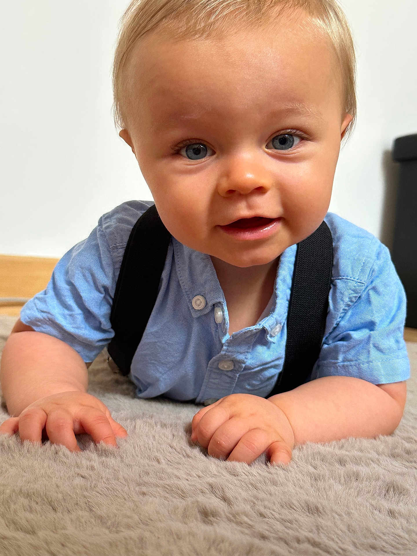 Elijah a rejoint le concours — aidez-le/la à gagner de superbes lots ! baby, child, face, blue_eyes, shirt, suspenders, hands, carpet, soft_texture, indoor, portrait, cute, infant, skin, person, close_up, young, light, expression, curious