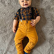 Elijah a rejoint le concours — aidez-le/la à gagner de superbes lots ! baby, child, smiling, plaid_shirt, suspenders, mustard_pants, blue_socks, lying_down, fluffy_rug, soft_texture, happy, cute, infant, casual_clothing, indoors, portrait, one_person, toddler, clothing, fashion