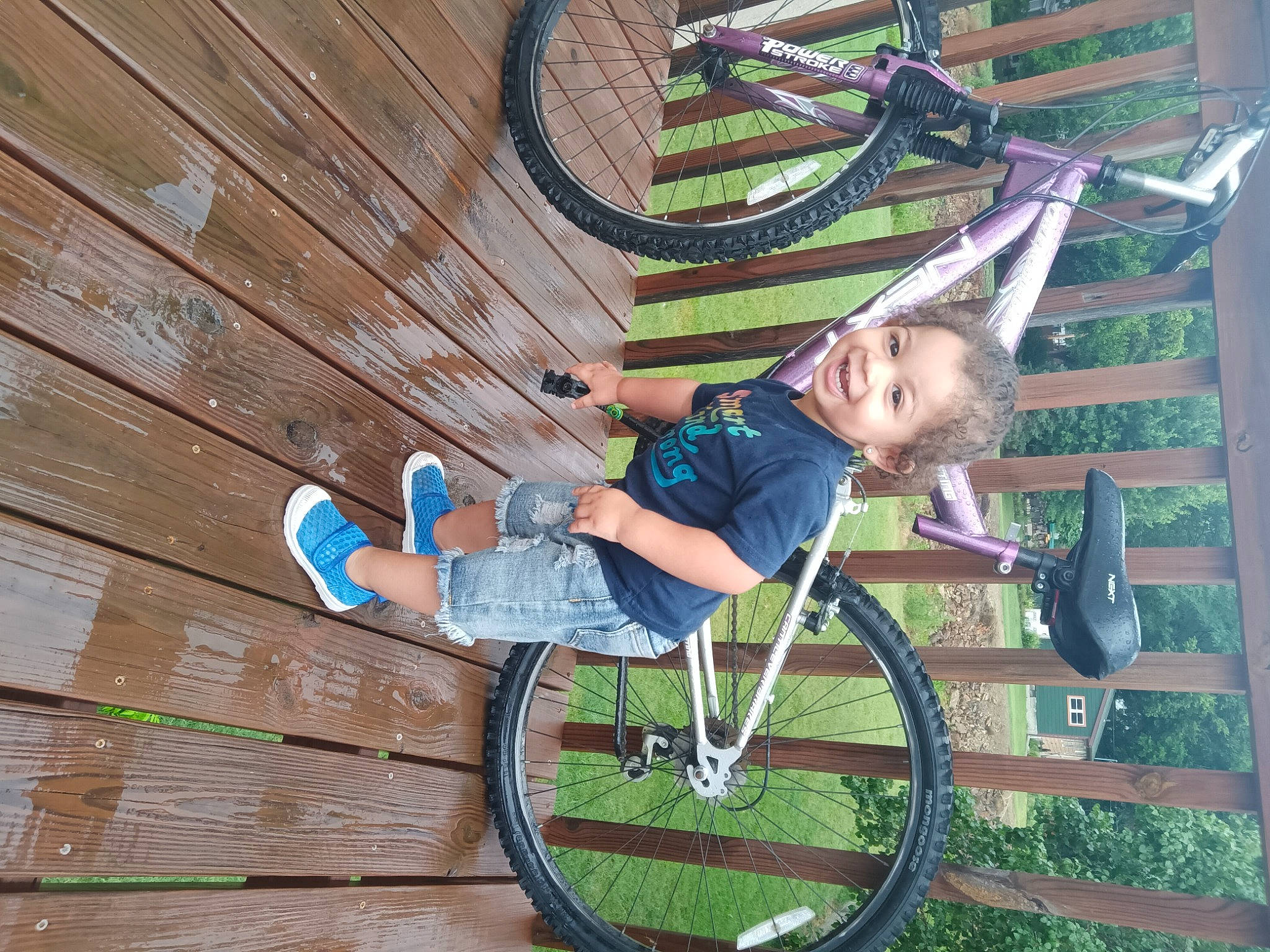 Levius is registered to the contest to win money with this photo: city, fun, grass, happy, joy, leisure, outdoor_play_equipment, outdoor_shoe, person, plant, recreation, sandal, shorts, sitting, smile, sneakers, swing, toddler, tree, walking_shoe