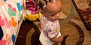 Jalynn Jr is registered to the contest to win money with this photo: barefoot, bedspread, carpet, child, clothing, colorful, curly_hair, cute, floor, hair_beads, hearts, indoor, looking_down, patterned_rug, room, shoes, standing, toddler, toy_box, young_child