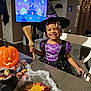 autumn_leaves, beads, broomstick, candy, child, costume, decorations, ghosts, hair, halloween, happy, haunted_house, holiday, indoor, party, pumpkin, smiling, table, television, witch_costume