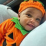 baby, car_interior, child, closeup, costume, cute, face, fall, green_collar, happy, hat, holiday, indoors, infant, orange_clothing, portrait, pumpkin_costume, seasonal, smiling, soft_fabric
