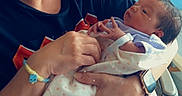 Alani joined the competition — help win amazing prizes! newborn, baby, infant, grandparent, adult, holding, portrait, indoors, hospital, blanket, onesie, glasses, smiling, family, caregiving, seated, chair, wristwatch, heart, photography