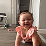 baby, child, infant, crawling, smiling, happy, portrait, indoor, home, hallway, floor, toy, pink_outfit, ruffles, curly_hair, face, hands, arms, video_call, smartphone_screenshot