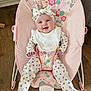 adorable, baby, baby_rocker, bib, child, comfort, cute, floral_pattern, footwear, happy, headband, indoor, infant, onesie, person, pink, playful, sitting, smiling, wooden_floor