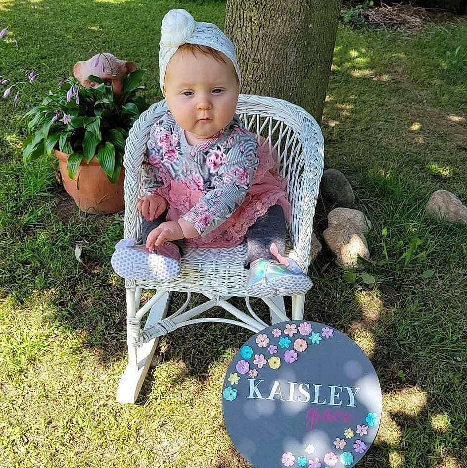 Kaisley is registered to the contest to win money with this photo: baby, baby_toddler_clothing, chair, child, eye, face, flower, flowerpot, folding_chair, furniture, grass, hat, human_body, lawn, mammal, outdoor_furniture, person, plant, toddler, tree