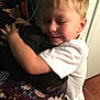 Odin joined the competition — help win amazing prizes! child, dog, hugging, indoor, affection, smiling, white_shirt, blond_hair, closed_eyes, bedspread, patterned_bedspread, floor, wall, door, hand, cuddling, happy, young_child, pet, love