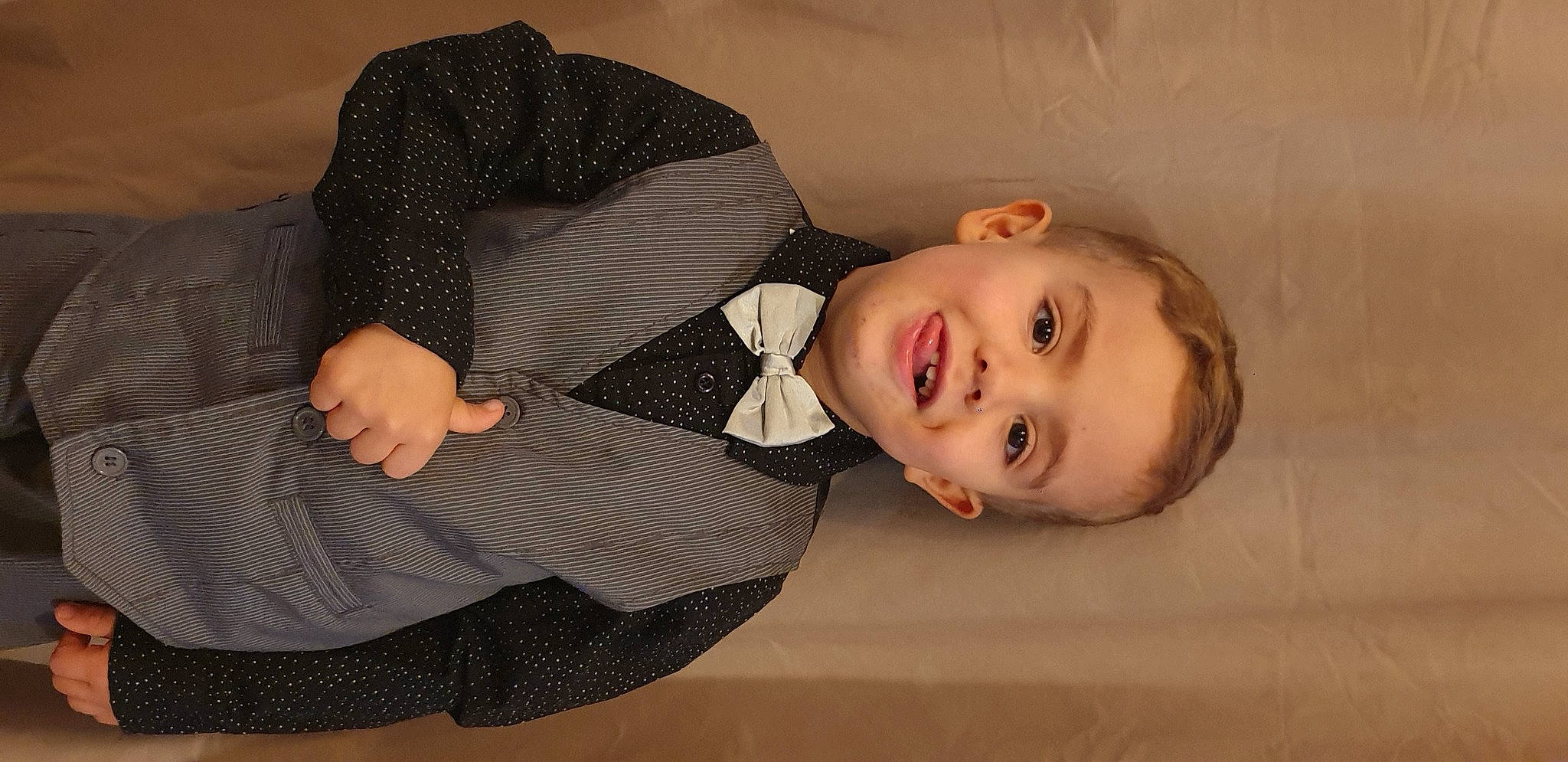 Ethan participe au concours pour gagner de l'argent avec cette photo : arm, baby_toddler_clothing, child, collar, comfort, dress, dress_shirt, elbow, finger, flash_photography, flooring, gesture, happy, joy, pattern, person, sleeve, smile, suit, tie